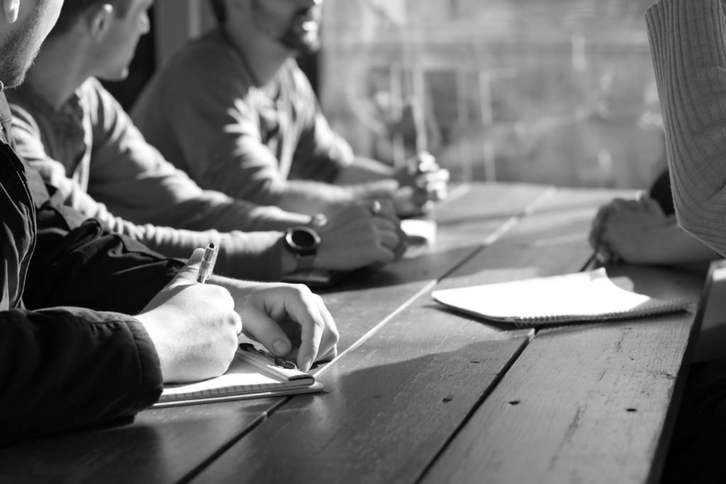 People discussing across a wood table