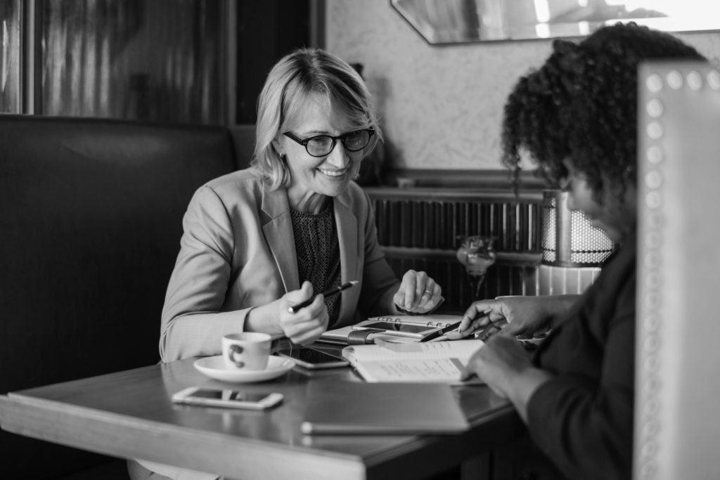 Two women meeting over coffee in a booth
