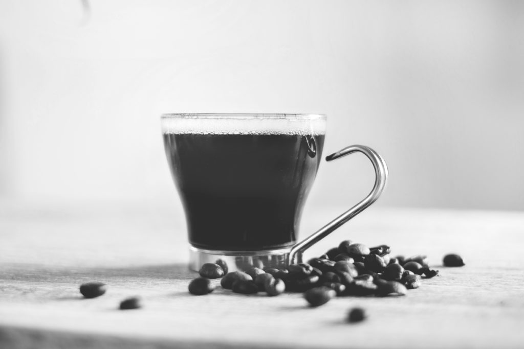 Black and white photo of a latte and espresso beans